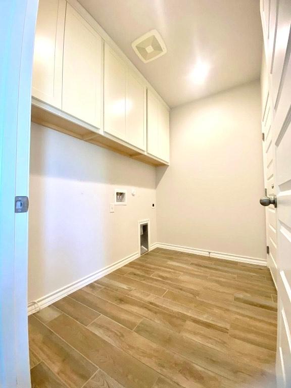 11713 Caithness Way, Austin, TX 78754 - laundry area featuring cabinet space, light wood finished floors, hookup for a washing machine, electric dryer hookup, and hookup for a gas dryer
