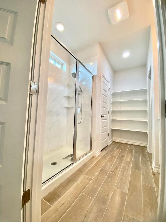 11713 Caithness Way, Austin, TX 78754 - full bathroom with wood finished floors, a shower stall, and recessed lighting