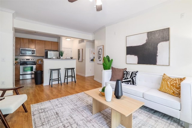 2502 Leon St Unit 208, Austin, TX 78705 - living room with ornamental molding, a ceiling fan, light wood finished floors, and baseboards