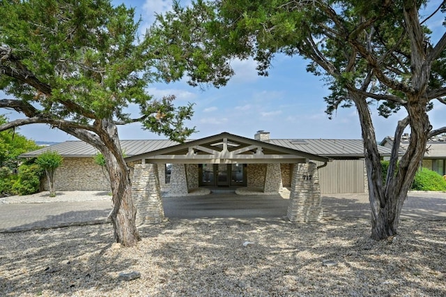 717 Mariner, Lakeway, TX 78734 - mid-century modern home with a standing seam roof, metal roof, stone siding, and a chimney