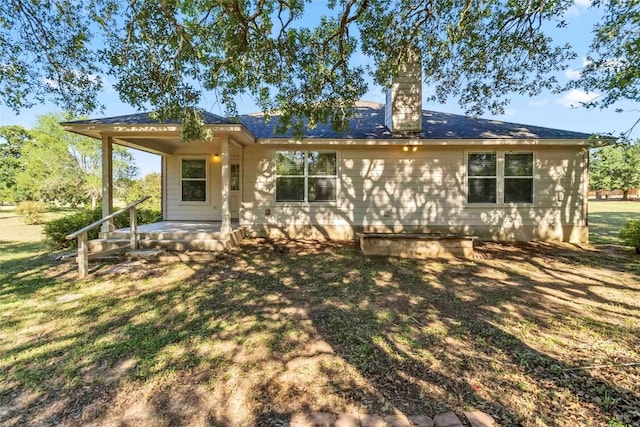 201 Murchison Dr, Cedar Creek, TX 78612 - view of front facade with a porch, a chimney, and a front yard