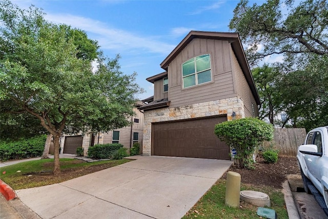 7709 Menchaca Rd Unit 14, Austin, TX 78745 - view of front facade with stone siding, board and batten siding, an attached garage, and concrete driveway