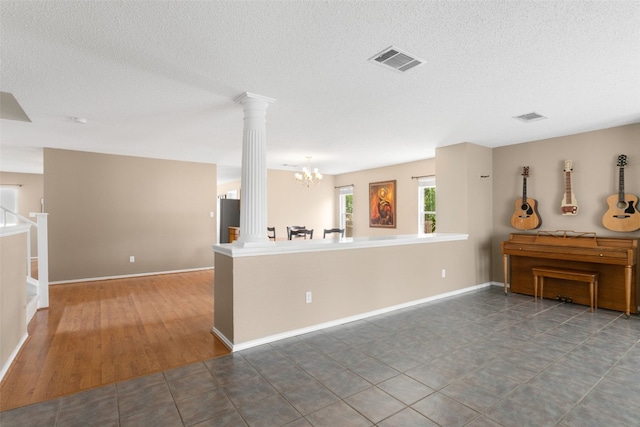 2105 Zeppelin Dr, Cedar Park, TX 78613 - living room featuring ornate columns, a chandelier, a textured ceiling, and baseboards