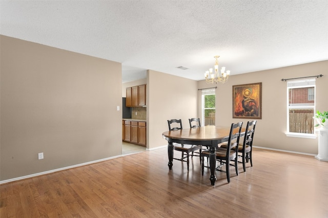 2105 Zeppelin Dr, Cedar Park, TX 78613 - dining room with a chandelier, light wood-style floors, and a textured ceiling