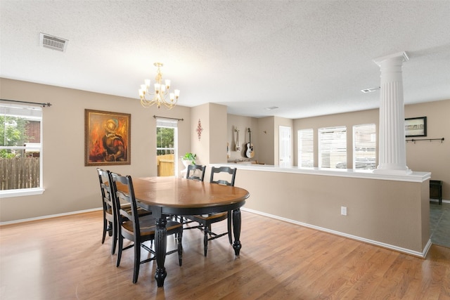 2105 Zeppelin Dr, Cedar Park, TX 78613 - dining room with decorative columns, light wood-style floors, a textured ceiling, and baseboards