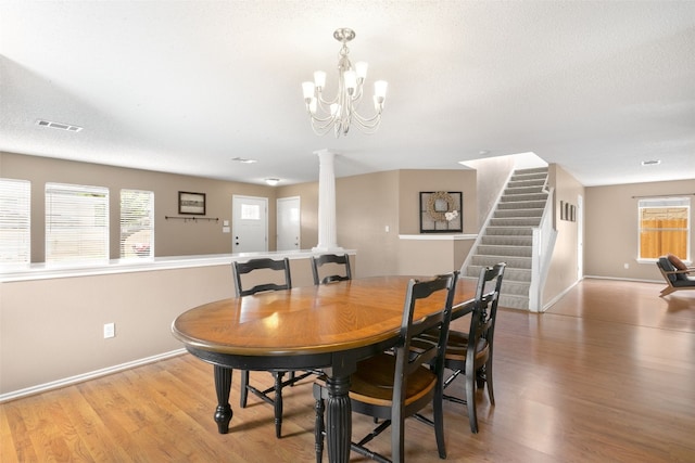 2105 Zeppelin Dr, Cedar Park, TX 78613 - dining area with decorative columns, baseboards, light wood-style floors, stairway, and a chandelier