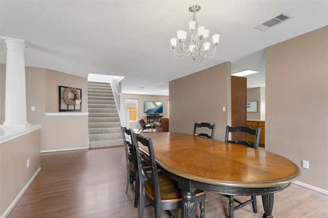 2105 Zeppelin Dr, Cedar Park, TX 78613 - dining room featuring ornate columns, wood finished floors, a chandelier, stairway, and baseboards