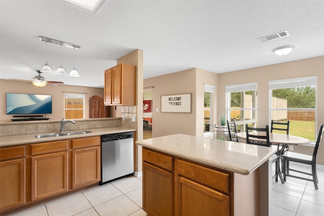 2105 Zeppelin Dr, Cedar Park, TX 78613 - kitchen with stainless steel dishwasher, a sink, a textured ceiling, light tile patterned flooring, and decorative light fixtures