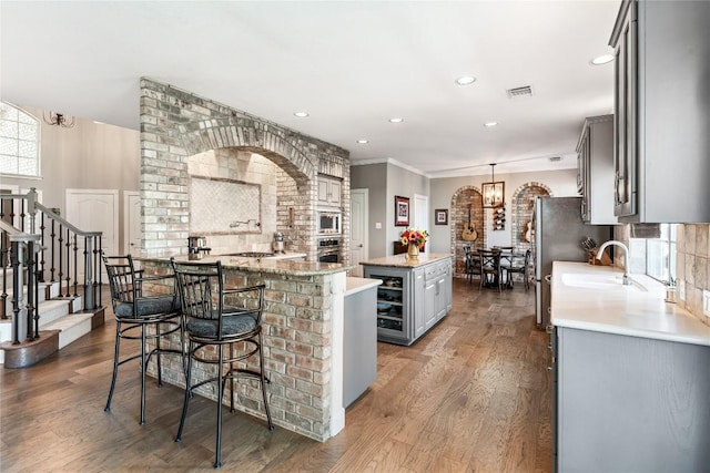 102 Cheerful Ct, Lakeway, TX 78734 - kitchen with gray cabinets, a kitchen island, stainless steel appliances, a chandelier, and a sink