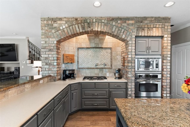 102 Cheerful Ct, Lakeway, TX 78734 - kitchen featuring appliances with stainless steel finishes, gray cabinetry, crown molding, recessed lighting, and tasteful backsplash