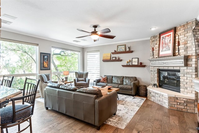 102 Cheerful Ct, Lakeway, TX 78734 - living room with crown molding, ceiling fan, a brick fireplace, and wood finished floors