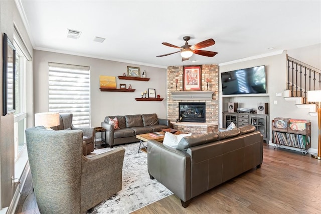 102 Cheerful Ct, Lakeway, TX 78734 - living area featuring wood finished floors, a ceiling fan, stairway, crown molding, and a fireplace