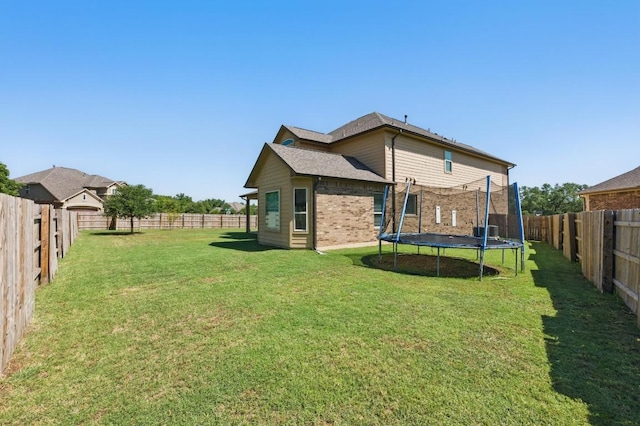 143 Pink Granite Blvd, Dripping Springs, TX 78620 - rear view of property with a trampoline and brick siding