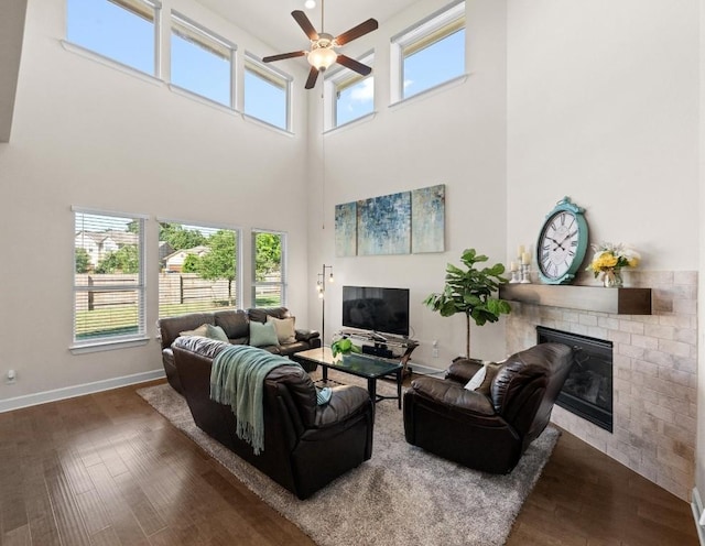 143 Pink Granite Blvd, Dripping Springs, TX 78620 - living area with ceiling fan, a brick fireplace, a towering ceiling, plenty of natural light, and dark wood-style floors