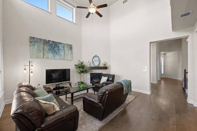 143 Pink Granite Blvd, Dripping Springs, TX 78620 - living area featuring ceiling fan, wood finished floors, a high ceiling, baseboards, and a glass covered fireplace