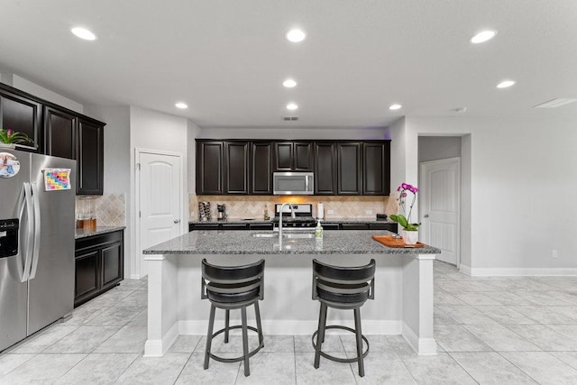 13911 Tribeca, San Antonio, TX 78245 - kitchen featuring stainless steel appliances, a sink, recessed lighting, light stone counters, and a kitchen bar