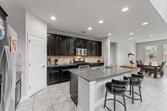 13911 Tribeca, San Antonio, TX 78245 - kitchen featuring stainless steel appliances, a sink, tasteful backsplash, light tile patterned floors, and stone counters