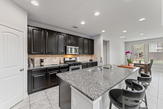 13911 Tribeca, San Antonio, TX 78245 - kitchen featuring appliances with stainless steel finishes, a sink, tasteful backsplash, light tile patterned floors, and light stone counters