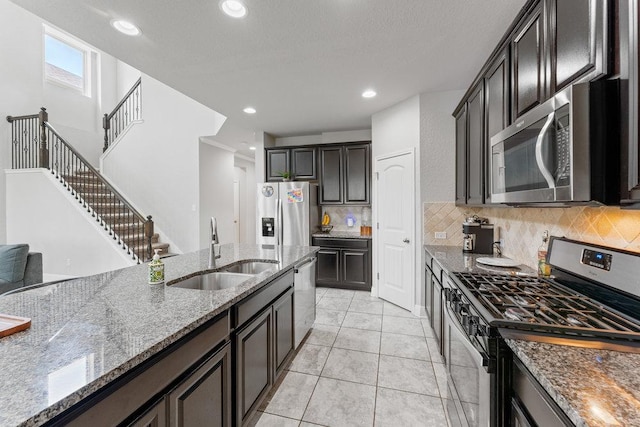 13911 Tribeca, San Antonio, TX 78245 - kitchen with appliances with stainless steel finishes, a sink, stone counters, decorative backsplash, and light tile patterned floors