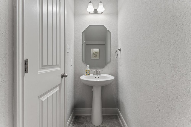 13911 Tribeca, San Antonio, TX 78245 - bathroom featuring baseboards, tile patterned flooring, and a textured wall