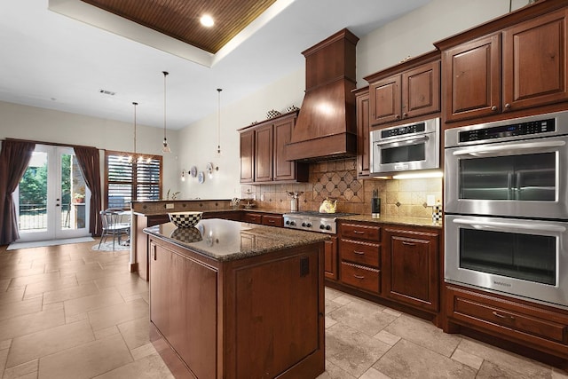 2904 Kodiak Cv, Cedar Park, TX 78613 - kitchen with appliances with stainless steel finishes, tasteful backsplash, a peninsula, a chandelier, and dark stone countertops