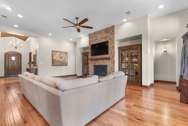 2904 Kodiak Cv, Cedar Park, TX 78613 - living area with light wood finished floors, a stone fireplace, a ceiling fan, recessed lighting, and a chandelier