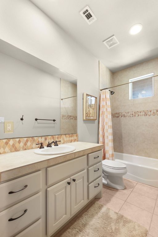 2904 Kodiak Cv, Cedar Park, TX 78613 - bathroom featuring vanity, toilet, tile patterned flooring, shower / bath combo with shower curtain, and backsplash