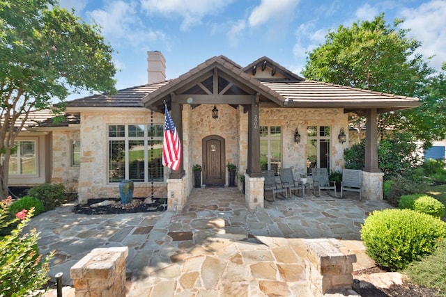 2904 Kodiak Cv, Cedar Park, TX 78613 - view of front of home with stone siding, a patio, a tile roof, and a chimney