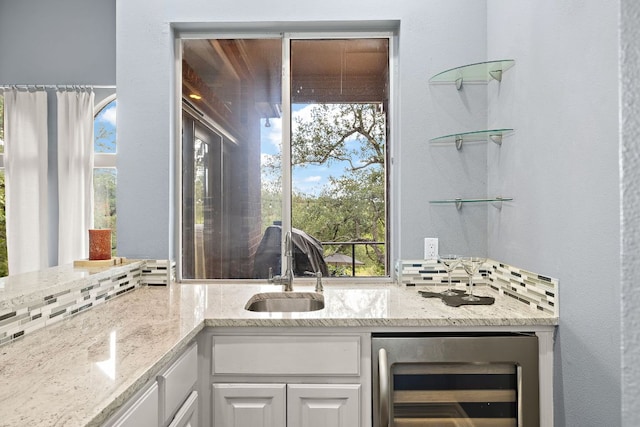 10003 Baxter Ln, Austin, TX 78736 - kitchen featuring beverage cooler, white cabinets, light stone counters, and healthy amount of natural light