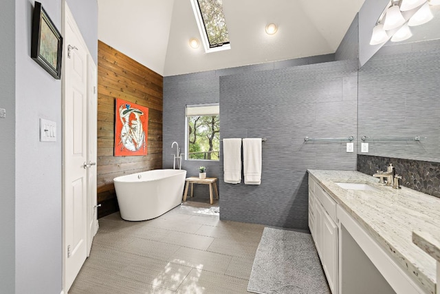 10003 Baxter Ln, Austin, TX 78736 - bathroom featuring vanity, high vaulted ceiling, a freestanding tub, a skylight, and wood walls