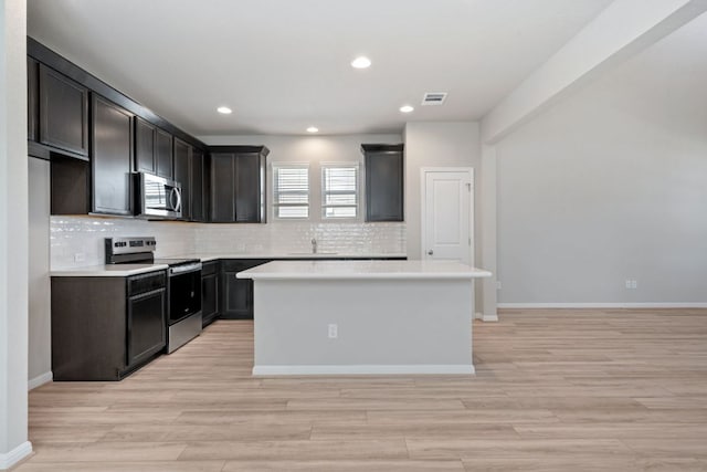 122 Elm Branch Trl, Taylor, TX 76574 - kitchen featuring stainless steel appliances, tasteful backsplash, a center island, light countertops, and recessed lighting
