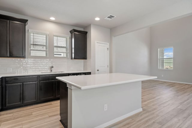 122 Elm Branch Trl, Taylor, TX 76574 - kitchen with light wood-type flooring, decorative backsplash, light countertops, a center island, and recessed lighting