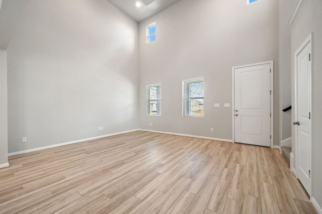 122 Elm Branch Trl, Taylor, TX 76574 - empty room featuring light wood-style flooring, a towering ceiling, and recessed lighting