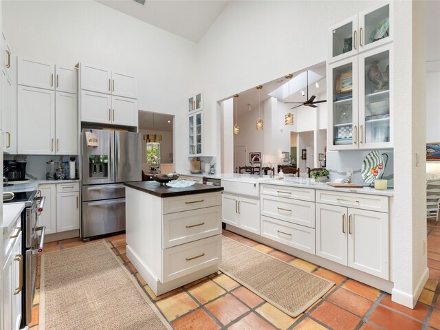 106 Southern Spur, Horseshoe Bay, TX 78657 - kitchen featuring stainless steel appliances, high vaulted ceiling, ceiling fan, a center island, and white cabinets