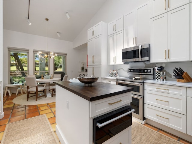 106 Southern Spur, Horseshoe Bay, TX 78657 - kitchen with stainless steel appliances, a warming drawer, butcher block countertops, a chandelier, and white cabinetry