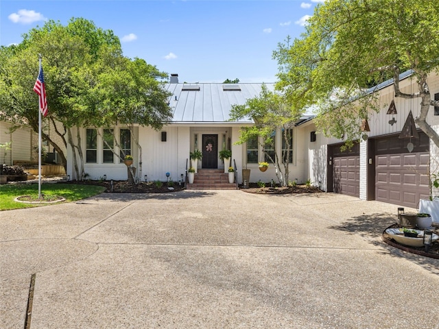 106 Southern Spur, Horseshoe Bay, TX 78657 - modern farmhouse with concrete driveway, a standing seam roof, a garage, and metal roof