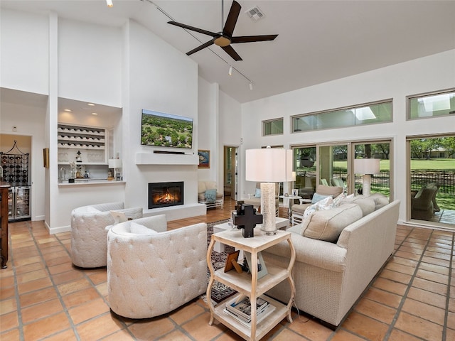 106 Southern Spur, Horseshoe Bay, TX 78657 - living room featuring high vaulted ceiling, wine cooler, a dry bar, a glass covered fireplace, and ceiling fan