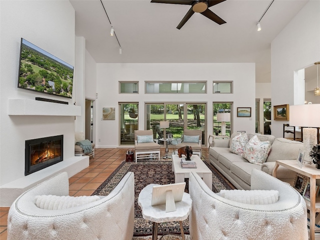 106 Southern Spur, Horseshoe Bay, TX 78657 - living area with track lighting, high vaulted ceiling, a ceiling fan, tile patterned floors, and a glass covered fireplace