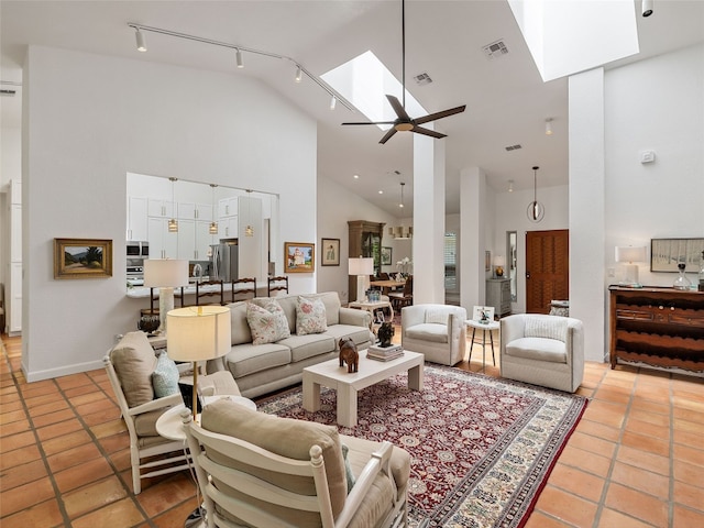 106 Southern Spur, Horseshoe Bay, TX 78657 - living area featuring a skylight, high vaulted ceiling, rail lighting, a ceiling fan, and light tile patterned floors
