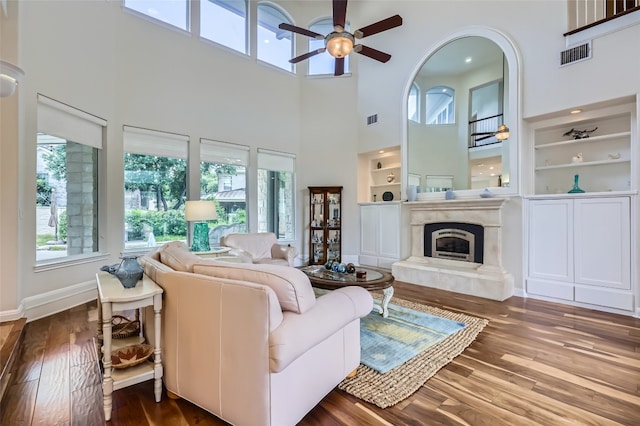 29 Tiburon Dr, The Hills, TX 78738 - living area with a towering ceiling, ceiling fan, wood finished floors, built in features, and a glass covered fireplace