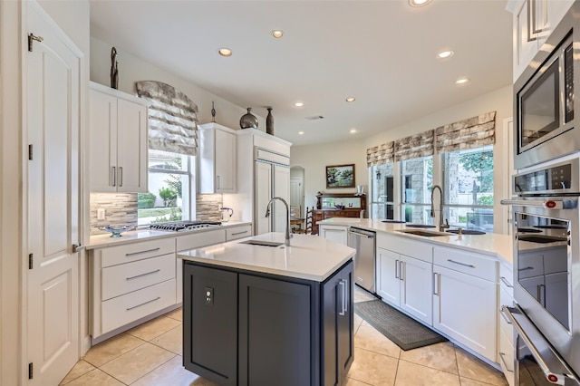 29 Tiburon Dr, The Hills, TX 78738 - kitchen with built in appliances, a kitchen island with sink, recessed lighting, light countertops, and white cabinets