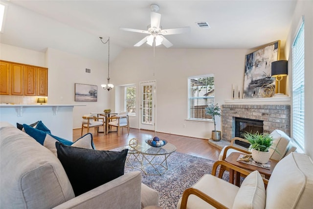 10500 Hendon St, Austin, TX 78748 - living area with ceiling fan, light wood finished floors, a fireplace, lofted ceiling, and a chandelier