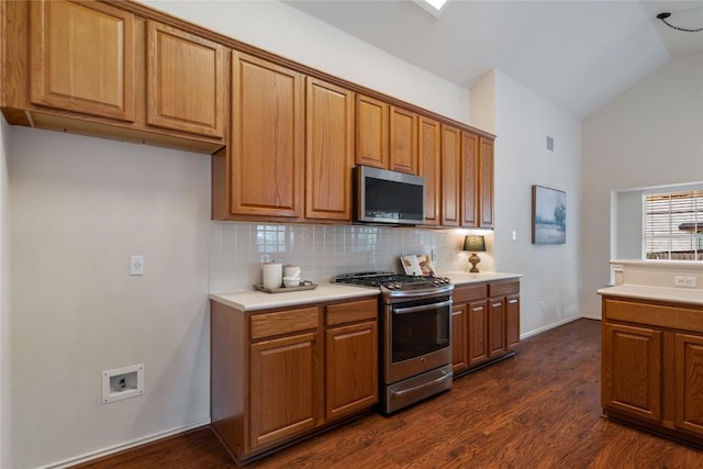 10500 Hendon St, Austin, TX 78748 - kitchen with stainless steel appliances, backsplash, dark wood-style flooring, brown cabinets, and high vaulted ceiling