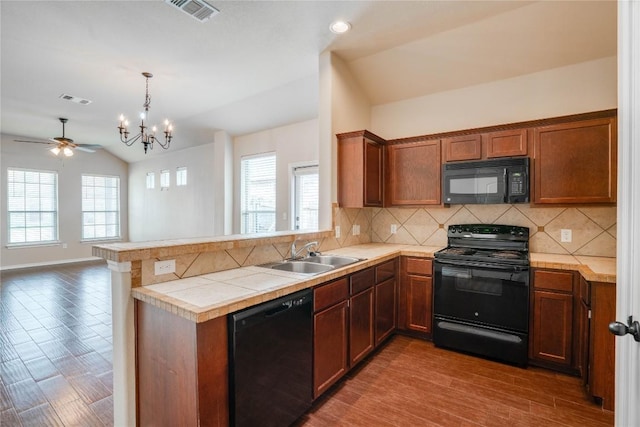 113-119 Creekside Villa Dr, Kyle, TX 78640 - kitchen featuring black appliances, a sink, vaulted ceiling, a peninsula, and backsplash