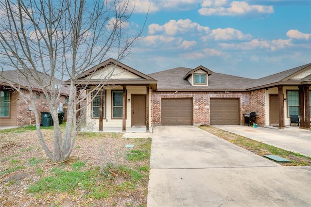 113-119 Creekside Villa Dr, Kyle, TX 78640 - view of front of property featuring brick siding, an attached garage, and driveway