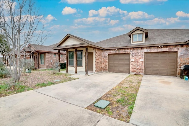 113-119 Creekside Villa Dr, Kyle, TX 78640 - view of front of home featuring brick siding, concrete driveway, an attached garage, and a shingled roof