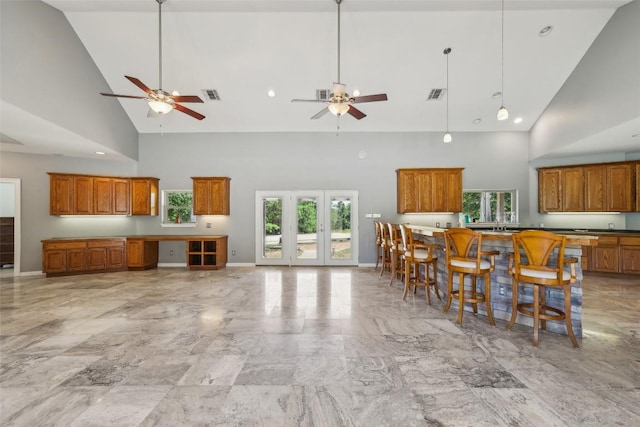 129 Country Air Dr, Bastrop, TX 78602 - kitchen featuring high vaulted ceiling, plenty of natural light, brown cabinetry, and ceiling fan
