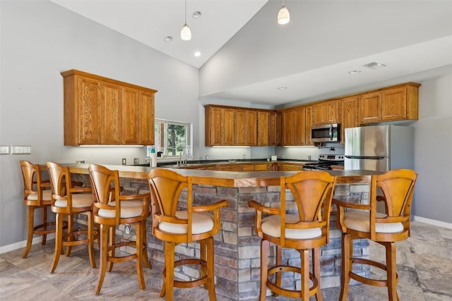 129 Country Air Dr, Bastrop, TX 78602 - kitchen featuring stainless steel appliances, brown cabinetry, high vaulted ceiling, and recessed lighting