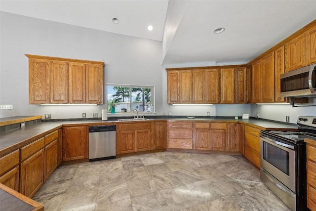 129 Country Air Dr, Bastrop, TX 78602 - kitchen featuring stainless steel appliances, brown cabinetry, light stone finish flooring, and recessed lighting