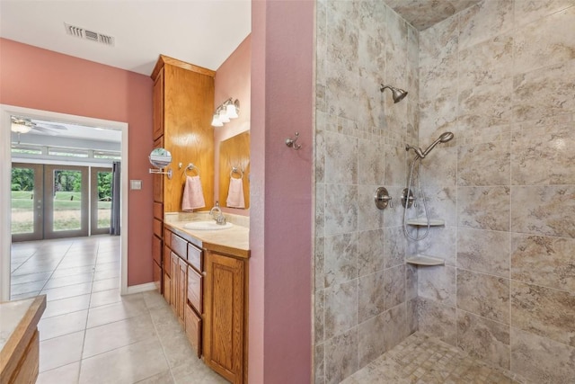 129 Country Air Dr, Bastrop, TX 78602 - full bathroom with vanity, a tile shower, french doors, tile patterned floors, and a ceiling fan